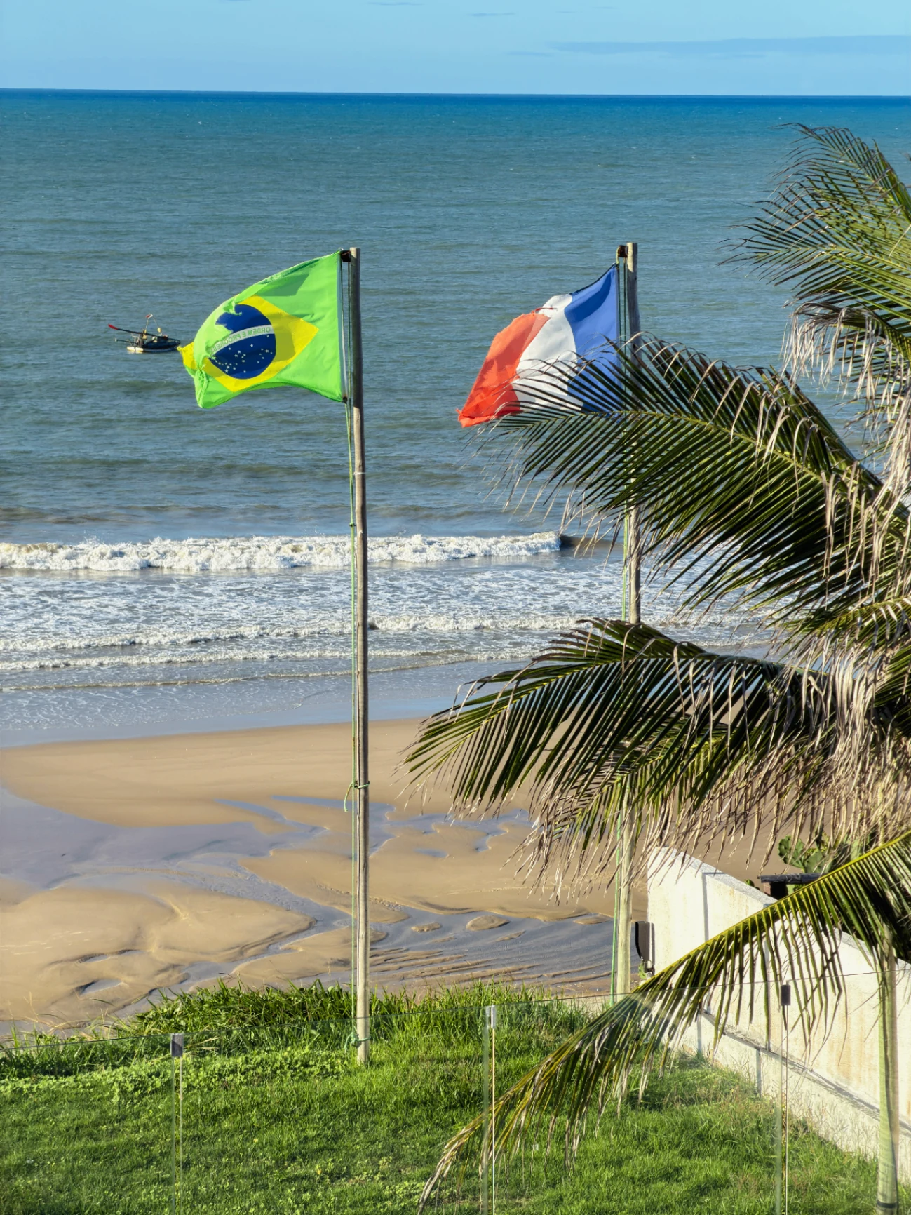 Vista da praia em frente à Casa La Baule com bandeiras do Brasil e da França