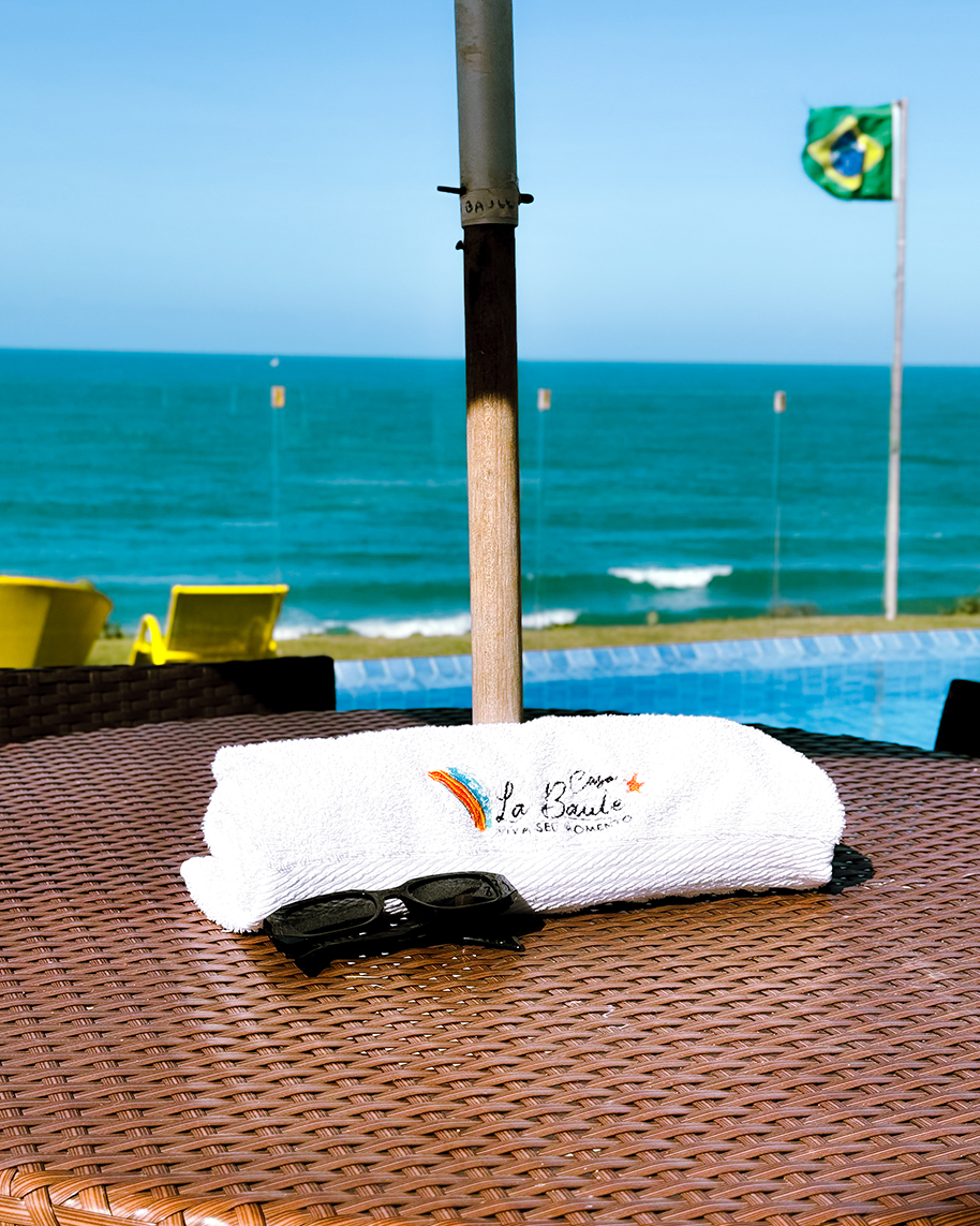 Toalha personalizada Casa La Baule dobrada sobre espreguiçadeira